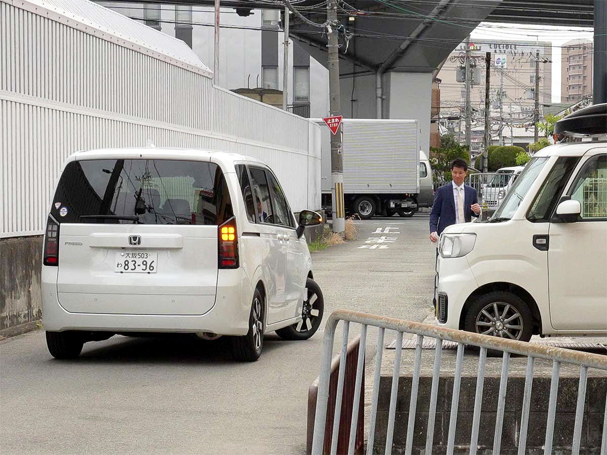 出口の順路を説明する従業員とお客様の乗り込んだレンタカー