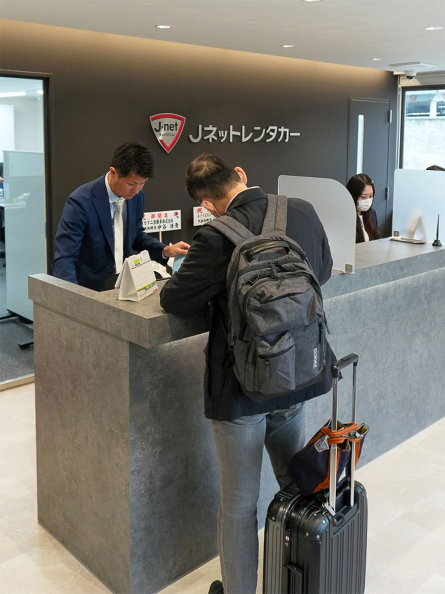 受付を済ませるお客様と説明する従業員